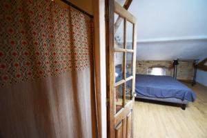 eine offene Tür zu einem Schlafzimmer mit einem Bett in der Unterkunft Maison de village proche Dordogne in Lacapelle-Biron