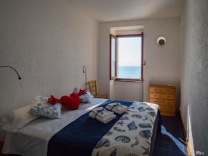 マナローラにあるLa Lampara Sea View Terrace Apartmentのベッドルーム(ベッド1台、動物の詰め物付)