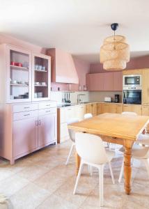 - une cuisine avec une table en bois et des chaises blanches dans l'établissement AG Casa Rural Carballo jardín y playa a 14km, à Artes