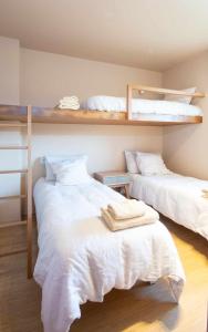 a bedroom with two beds with white sheets at AG Casa Rural Carballo jardín y playa a 14km in Artes