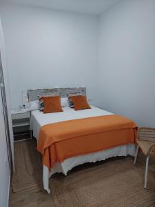 1 dormitorio con 1 cama grande con manta naranja en Orange Suite by Alhaurín Loft City Center, en Alhaurín de la Torre