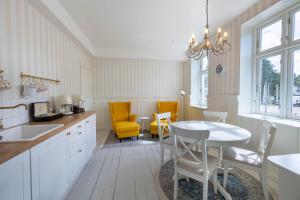 a kitchen with a table and two yellow chairs at Velling Koller Hotel og Camping in Bryrup