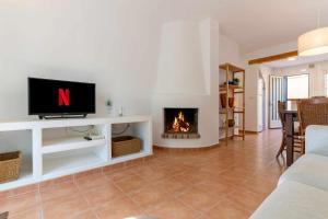 sala de estar con TV y chimenea en rentafive Urb Piscina Chalet Terrazas 23143, en Santa Pola