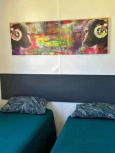 1 dormitorio con 2 camas y un cuadro en la pared en les bungalows de Lisa Maria, en SERRA DI FIUMORBO