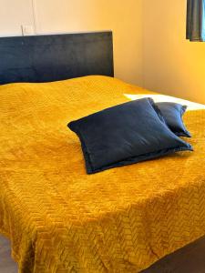 Una cama amarilla con una almohada azul. en les bungalows de Lisa Maria, en SERRA DI FIUMORBO