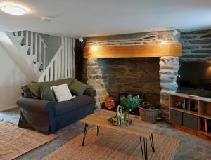 ein Wohnzimmer mit einem Sofa und einem Steinkamin in der Unterkunft Craig View Fishermans Cottage nr Harbour and Beach in Barmouth