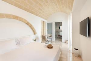 ein Schlafzimmer mit einem weißen Bett und einem Tisch in der Unterkunft Mastropà Exclusive Resort in Massafra + 157 Fotos
