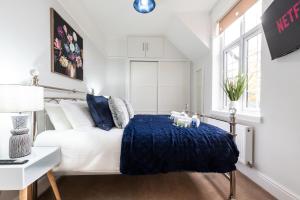 a bedroom with a white bed with a blue blanket at Elegant 2 Bedroom Seymour Apartment by Smart Apartments in Southampton