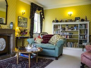 a living room with a blue couch and a fireplace at Dowfold House Bed and Breakfast in Crook