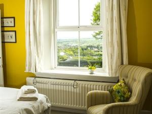 a bedroom with a bed and a window and a chair at Dowfold House Bed and Breakfast in Crook