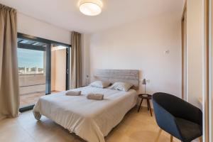 Fuente-Álamo de Murcia的住宿－App Paraïso - Golf Resort Hacienda，一间卧室设有一张大床和一个大窗户