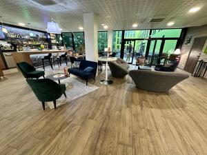 eine Lobby mit Stühlen, Tischen und einer Bar in der Unterkunft Campanile Belfort Montbéliard - Gare La Jonxion. in Meroux