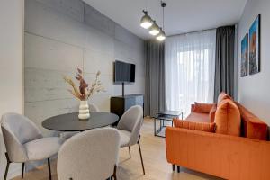 a living room with a couch and a table and chairs at Downtown Apartments City Center Angielska Grobla in Gdańsk