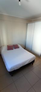 een bed in een kamer met witte lakens en bruine kussens bij Dpto. zona sur - Ubicación ideal in Santa Fe