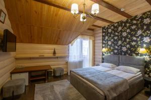a bedroom with a bed and a desk and a television at Korona Hotel&SPA in Bukovel