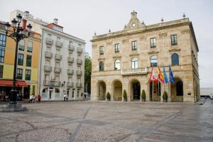 a large building with flags in front of it at Hotel Asturias in Gijón +28 photos