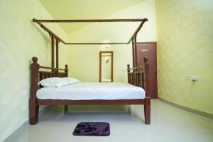 a bedroom with a bed with a wooden frame at Mohor 56 in Shānti Niketan