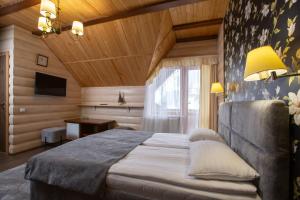 a bedroom with a bed and a television in a room at Korona Hotel&SPA in Bukovel