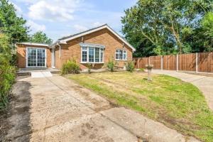 a brick house with a fence at Amazing bungalow with hot tub in Lessingham