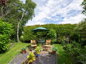 a garden with a table and chairs and an umbrella at 2 Bed in Stokesley 75544 in Stokesley