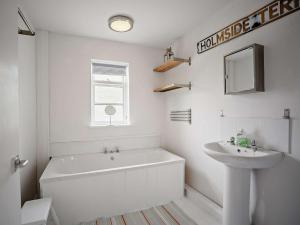 a white bathroom with a tub and a sink at 3 Bed in Nr Embleton CN156 in North Charlton