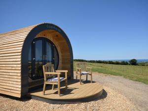 a small building with two chairs on a wooden deck at 1 Bed in St Davids 62569 in Abercastle