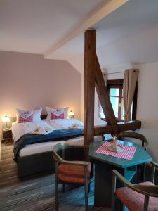 sypialnia z łóżkiem i stołem w pokoju w obiekcie Auersberg Haus w mieście Eibenstock