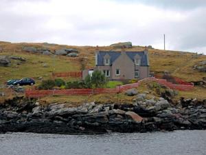 una casa en la cima de una colina junto al agua en 3 Bed in Isle of Barra CA295, en Ersary