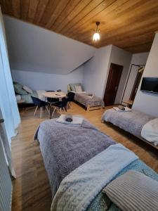 Habitación con 2 camas, sofá y mesa. en TatroManiac Zakopane Pokoje, en Zakopane