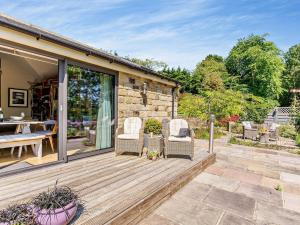 a wooden deck with two chairs and a table at 2 Bed in Nidderdale G0156 in Hampsthwaite