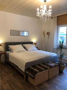 1 dormitorio con 1 cama grande y lámpara de araña en Villa Adlon, en Hochheim am Main