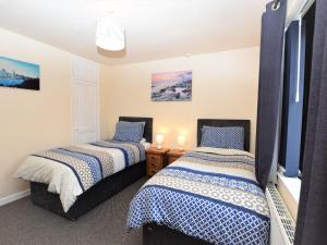 two beds in a room with two lamps at 5 bed in Brynteg 75907 in Llanwenog