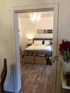 1 dormitorio con cama y lámpara de araña en Villa Adlon, en Hochheim am Main