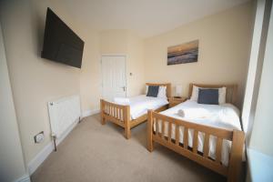 a bedroom with two beds and a flat screen tv at lfracombe Holiday Apartment Close to Tunnels Beaches in Ilfracombe