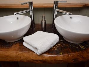 2 lavandini bianchi su un bancone in legno in bagno di 1 Bed in Bodiam 74237 a Bodiam