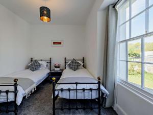 two beds in a room with a window at 2 Bed in Bude 75046 in Kilkhampton