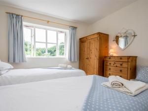 a bedroom with two beds and a window at 3 Bed in Studland DC072 in Studland