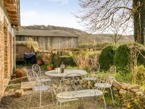 un patio con mesa y sillas en un jardín en 2 Bed in Tiverton 77442 en Washfield