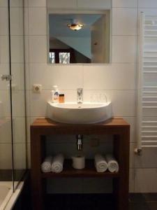 a bathroom with a sink and a mirror and towels at Herberg St. Brigida in Noorbeek