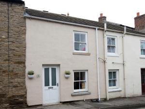 a white house with two windows and two potted plants at 1 Bed in Richmond G0180 in Richmond