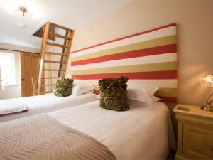 dwa łóżka w pokoju ze ścianą w paski w obiekcie 1 Bed in Howden G0181 w mieście Saltmarshe