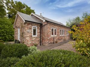 un ancien bâtiment en briques au milieu d'un jardin dans l'établissement 1 Bed in Howden G0181, à Saltmarshe