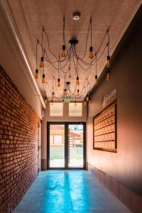 a hallway with a chandelier and a brick wall at Central Residence in Baia Mare