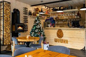 a christmas tree in a restaurant with a table and chairs at Шишка in Bukovel