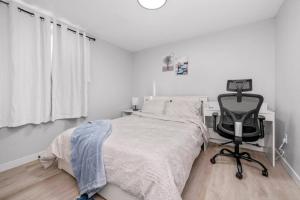 a bedroom with a bed and a desk and a chair at CenterStreet-Cozy 2bedroomSuite in Calgary