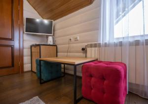 una camera con tavolo e sedia rosa di Korona Hotel&SPA a Bukovel