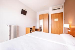 A bed or beds in a room at HOTEL LA PERLA