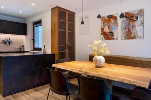 Il comprend une cuisine et une salle à manger avec une table et des chaises en bois. dans l'établissement Apartment UB Two, à Eggen