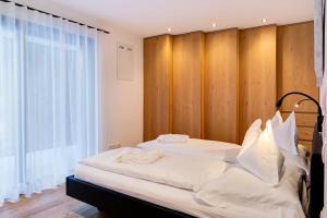 - une chambre avec un grand lit et un mur en bois dans l'établissement Apartment UB Two, à Eggen