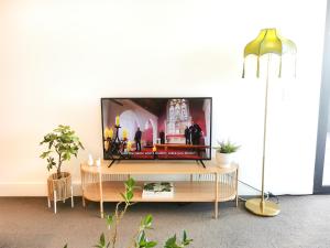 sala de estar con TV de pantalla plana sobre una mesa en French Country Style in Olympic Park, en Sídney